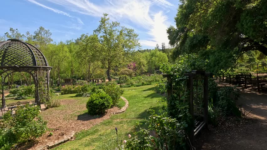footage of a gorgeous spring landscape with a gazebo, colorful flowers and lush green trees and plants at Descanso Gardens La Canada Flintridge California USA