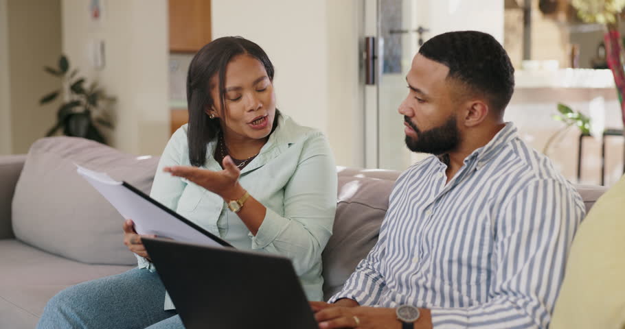 Laptop, documents and angry couple fight on a sofa with bill, drama or gambling addiction in their home. Financial, conflict and frustrated people with divorce, documents or asset management argument