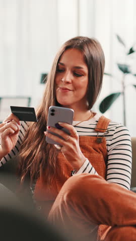 Credit card, phone and woman on sofa for online shopping, purchase and payment in home. Ecommerce, happy and person on smartphone for website sale, discount and internet banking in living room