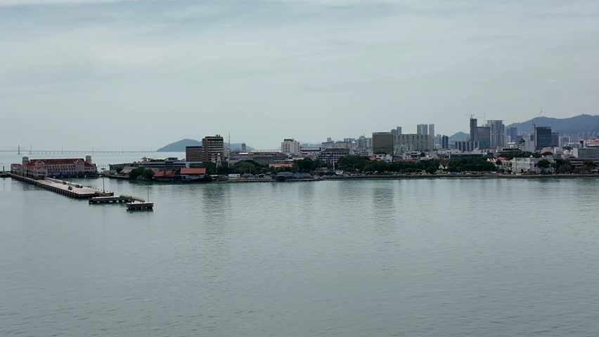 Central business district of Penang, Malaysia with mountains behind waterfront condos and office buildings. Popular expat retirement tropical island destination in Southeast Asia.