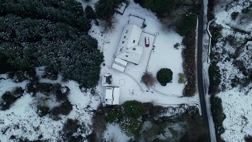 Bird eye view of a mountain road next to a mountain house in a snow day - Dublin Mountains - Ireland