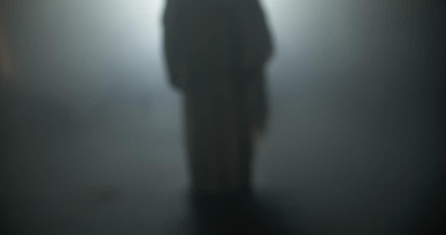 Silhouette of resurrection of Jesus Christ inside the tomb, in bright light, raising his hands in dramatic, cinematic slow motion. Perfect for Easter resurrection visual.