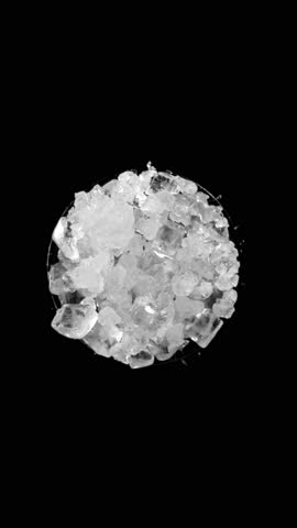 Super slow motion of rotating crushed ice, top view shot. Filmed on high speed cinema camera, 1000 fps. Isolated on black background. Vertical aspect ratio.