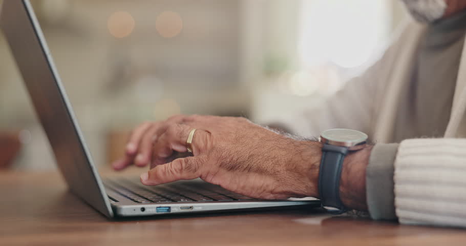 Senior man, hands and laptop for typing in home, online search and scroll on news website. Elderly male person, writing and network for communication, closeup and internet connection in retirement