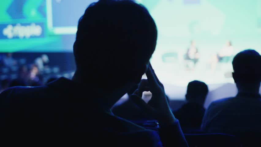 Attendee following crypto conference presentation