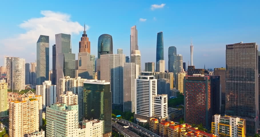 Aerial view of city skyline of Guangzhou's central business district featuring modern skyscrapers under a clear blue sky.