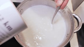 Slow motion pour of semolina into milk pot, a calm morning cooking routine - Powered by Shutterstock - Get 15% off with code: PIKWIZARD15