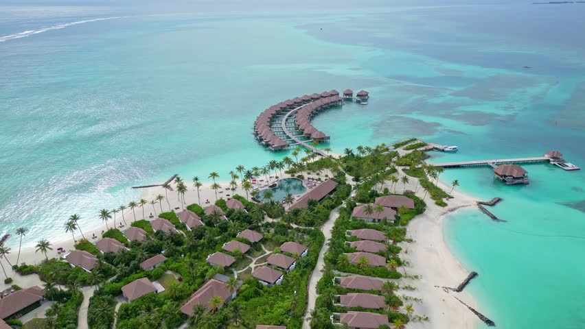Aerial view over holiday bungalows at a vacation resort, sunny day in Maldives