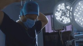 A surgeon ties a surgical cap in preparation for an operation in a hospital operating room. The setting is clean and well-lit with advanced medical equipment ready for the procedure.
 - Powered by Shutterstock - Get 15% off with code: PIKWIZARD15