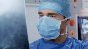 A surgeon in a surgical mask carefully examines an X-ray on a screen, preparing for a medical procedure. The operating room is equipped with advanced medical technology to aid in patient care.
 - Powered by Shutterstock - Get 15% off with code: PIKWIZARD15