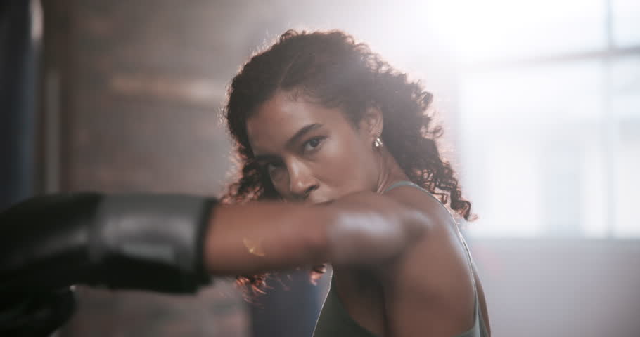 Boxing, face and girl in gym for punch, training and preparation for mma competition. Fitness center, professional and female boxer with gloves for power, energy and workout for sports challenge