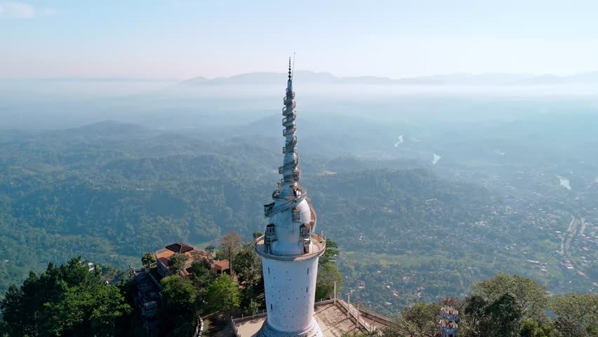 Experience the grandeur of Ambuluwawa Tower close to Kandy city at sunrise, captured from a drone.