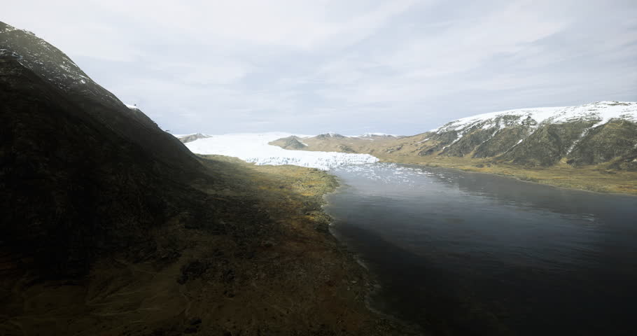 A breathtaking view features a wide glacier extending into a calm lake surrounded by rugged mountains. The clear skies reveal a serene summer atmosphere in a remote location.