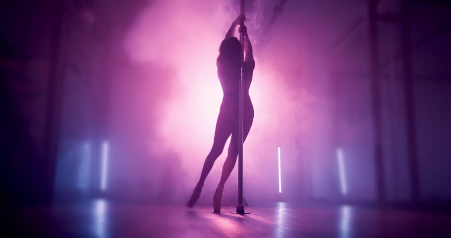 Pole, dancing and woman in club on a stage for choreography, creativity and balance for concert. Dark, silhouette and female exotic dancer with entertainment by lights for performance at VIP party.