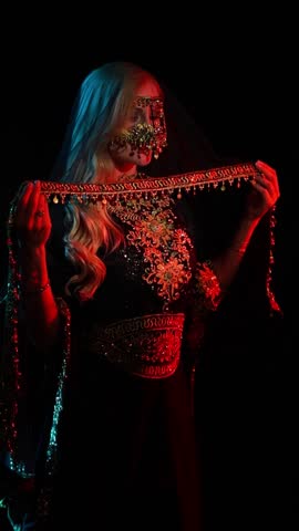 Dancer in black and gold oriental costumes, belly dance on the black background