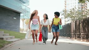 Three joyful friends enjoying an exhilarating day out while carrying their colorful shopping bags and laughing together on a beautiful sunny afternoon filled with excitement and camaraderie - Powered by Shutterstock - Get 15% off with code: PIKWIZARD15