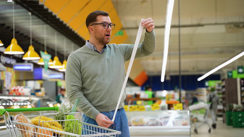 Man shocked by long grocery receipt and rising inflation