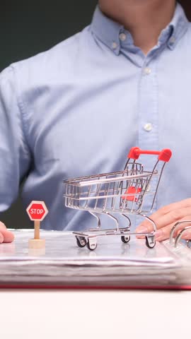 vertical video Office worker stopping online shopping impulse with miniature stop sign