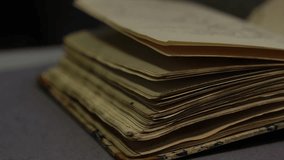 Close-up: An archivist wearing gloves carefully flips through an old handwritten book. Valuable historical document, ideal for themes of research, heritage, and antique preservation - Powered by Shutterstock - Get 15% off with code: PIKWIZARD15
