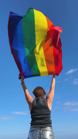 Gay pride parade, woman woman holding flag with rainbow lgbt flags