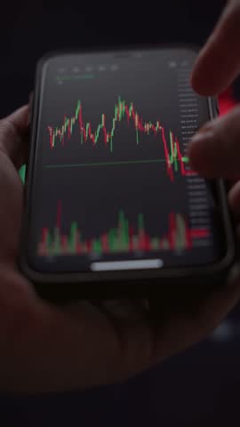 Close up of businessman hands using stock market app on smartphone, viewing candlestick diagram and data trends for online trading and investment.