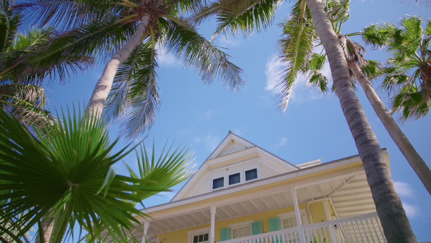 Experience breathtaking ocean views at this beautiful beachfront house in Key West, surrounded by palms and a vibrant sky, embodying Floridas tropical paradise for a perfect getaway
