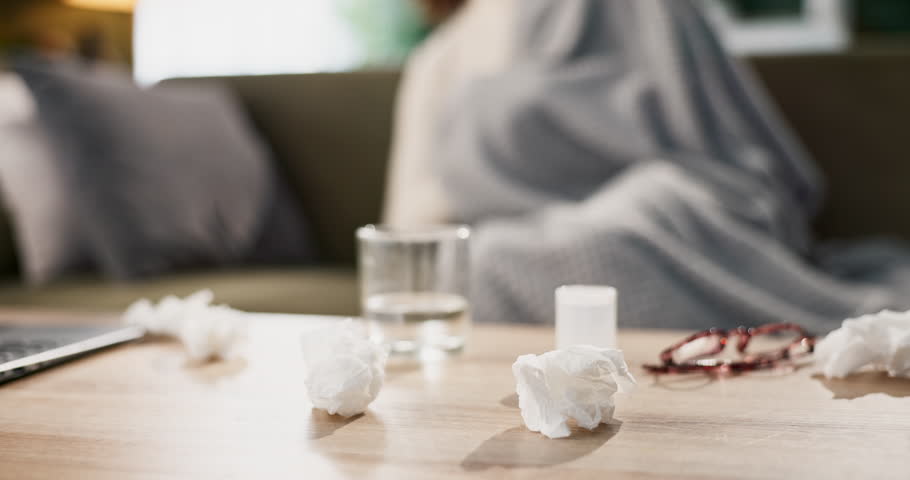 Tissues, sick and sleep for woman on couch, blanket and relax or comfort for rest in home. Couch, cold and illness for female person in living room, sinus and allergies or fatigue for healthcare