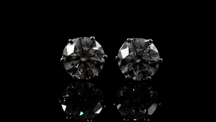big beautiful bright and shine diamond earring on the mirror with balck background