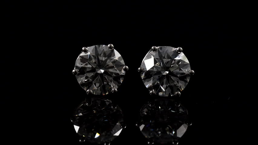 big beautiful bright and shine diamond earring on the mirror with balck background