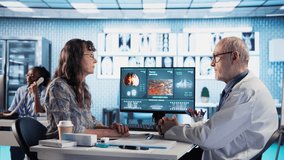 Male oncology specialist reviewing a radiology scan with elderly woman patient, explaining risk factors and preventive options for cancer diagnosis and treatment. Immunotherapy. - Powered by Shutterstock - Get 15% off with code: PIKWIZARD15