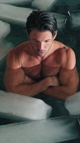 Attractive Man Standing in Cold Water of Swimming Pool with Ice Cubes for Body Health. Fitness Person in Bathtub Filled with Frost Liquid for Youth Treat. Beauty Routine of Healthy Male in Large Bath
