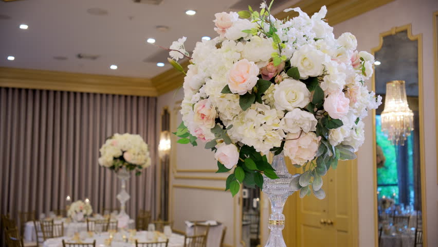 Flower installation on the table at the restaurant, as element of the wedding decoration at the event. Move camera shot - Powered by Shutterstock - Get 15% off with code: PIKWIZARD15