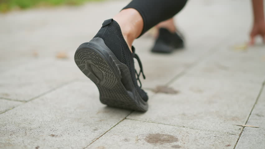 Back view of runner's leg in black sneakers taking off, athletic movement, sprinting, quick start, energy, powerful stride, workout action, fitness, dynamic motion, outdoor running