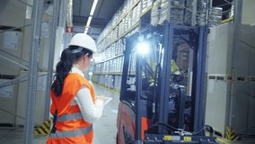 In a warehouse, a woman in an orange vest points at a man in a yellow jacket operating a forklift, indicating a discussion on logistics and storage organization. - Powered by Shutterstock - Get 15% off with code: PIKWIZARD15