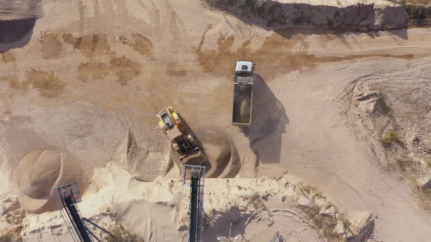 Aerial view of stone quarry conveyor belt system in operation, stone jaw crusher plant