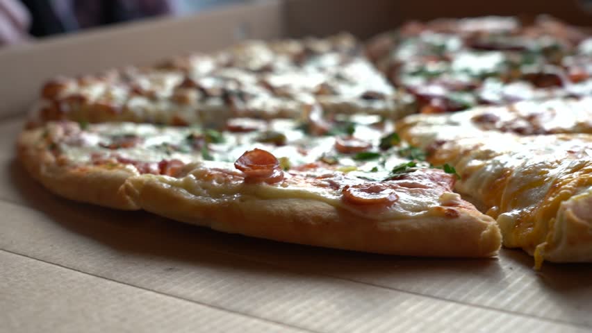 Four types of pizza with different toppings on the table are an ideal solution for a large company with different tastes.