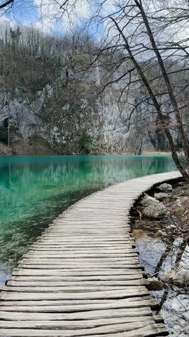 Beautiful and amazing panoramic view of the wooden pathway with turquoise colored lakes in serene setting of forest inside the Plitvice Lakes National Park in Croatia, Balkan