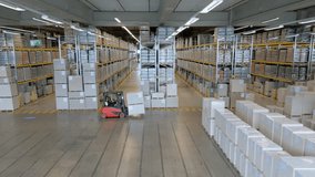 A vast warehouse with high ceilings and metal racks filled with goods. A forklift navigates the aisles, highlighting the efficient storage and logistics system. - Powered by Shutterstock - Get 15% off with code: PIKWIZARD15