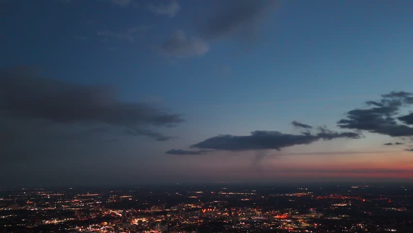 An aerial view of urban cityscape of Waterloo illuminated in the evening, with a scenic dusk sky in the background in Ontario, Canada