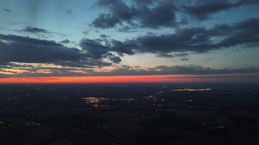 An aerial view of urban cityscape of Waterloo illuminated in the evening, with a cloudy dusk sky in the background in Ontario, Canada