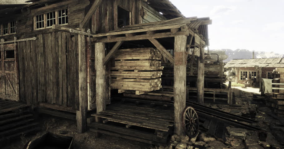 A weathered wooden building features an overhang supporting stacked pallets. The structure is surrounded by a rugged landscape and hints of a historic atmosphere.