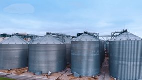 Flying closer to the tanks for processing and storing wheat grain. Modern agricultural enterprise. Grain business concept. - Powered by Shutterstock - Get 15% off with code: PIKWIZARD15