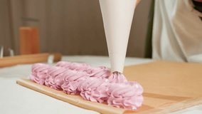 Close up of cupcake preparation showing piping bag forming swirls of fluffy pink dough on brown baking paper in neat row during baking process inside cozy kitchen with soft lighting and rustic decor - Powered by Shutterstock - Get 15% off with code: PIKWIZARD15