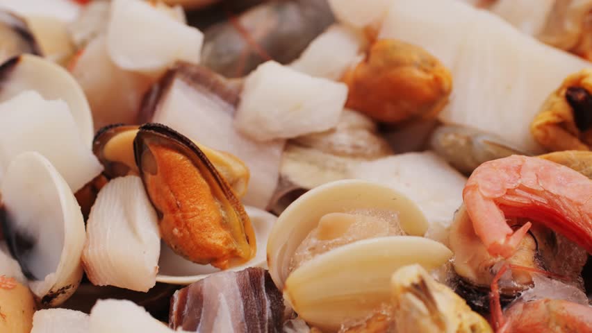 Paella mix, Roasted Mixed Seafood Contain Blue Crabs, Mussels, Big Shrimps, Calamari Squids and Grilled Barracuda Fish Garlic with Spicy Chili Sauce and Lemon on Dish, close up supermarket food.