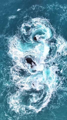 Ocean waves crashing intensely over rocky shoreline. Vertical video