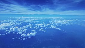 View from airplane window scattered white clouds floating above a vast landscape, with winding rivers below. The deep blue sky and soft cloud formations create a sense of serenity and vastness. - Powered by Shutterstock - Get 15% off with code: PIKWIZARD15