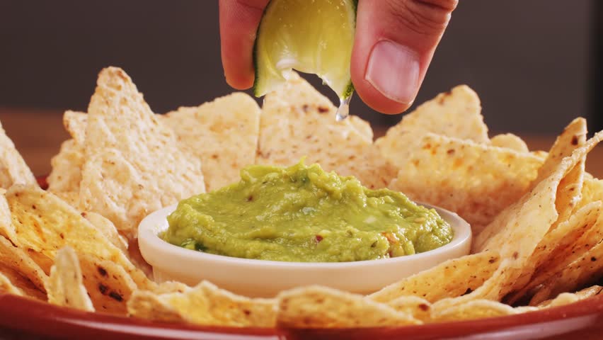 Nachos with Guacamole dip, traditional mexican food in restaurant for nachos, close up of avocado plate for vegetarians.