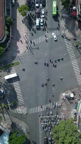 Aerial top-down view of busy street intersection full of motorbikes, scooters, and cars in Ho Chi Minh City (Saigon), Vietnam