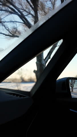 Vertical Video of Snowy winter road in pine and birch forest. Landscape with highway going through the winter forest. Car speeding on a road. Side window view of auto in motion. Tourism and travel.