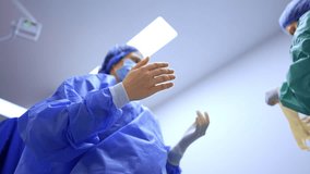 Nurse takes latex gloves and helps the doctor to wear them. Surgeon's preparation before operation. Low angle view. - Powered by Shutterstock - Get 15% off with code: PIKWIZARD15
